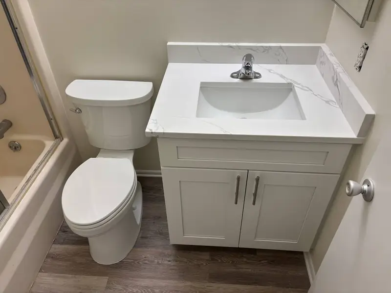Bathroom vanity, toilet, and shower after fixture installation