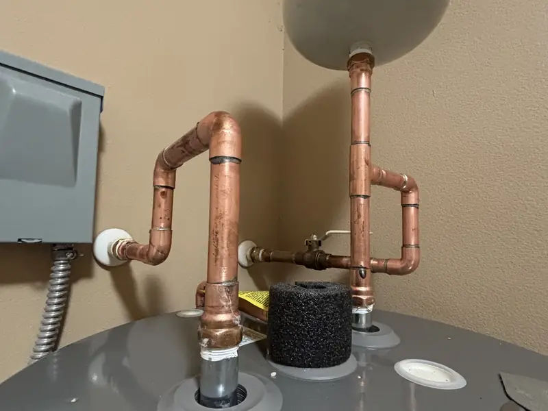 New copper supply connections and fittings on top of a water heater
